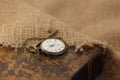 Ancient pocket watch and key on old folio half-covered with old sackcloth. Time passing concept. Knowledge eternity concept Royalty Free Stock Photo