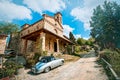 An ancient Porsche is parked outside of a countryside church in the Tuscan hills of Chianti, between Pisa and Florence