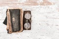 Ancient prayer book with round spectacles 1920s and case on the wooden table, top view, space for text or design elements