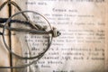 Ancient prayer book with spectacles on top, Old Slavic text in the book, top view, macro