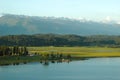 An ancient relict lake in Pitsunda. Mountains covered with snow in the background. Voluminous white clouds hang over the