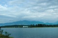 An ancient relict lake in Pitsunda. Mountains covered with snow in the background. Voluminous white clouds hang over the