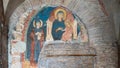 Ancient religious fresco decorating ruins of old stone church in Italy