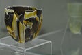 Ancient renovated bowl made of polychrome glass strips of brown, black and yellow colours