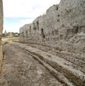 The ancient rocky entrance to the Greek amphitheater with votive aedicule in Neapolis Archaeological Park in Syracuse, Italy Royalty Free Stock Photo