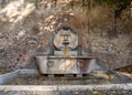 Ancient roman fountain carved in marble as a male hairy face