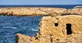 An ancient Roman ruin stands alone against a stunning backdrop of shimmering sea and rolling hills Royalty Free Stock Photo