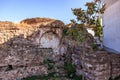 Ancient roman ruins with arch and tree in sunlit outdoor setting Royalty Free Stock Photo