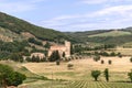 The ancient Romanesque abbey of Sant Antimo Abbazia di Sant`Antimo in the middle of an olive grove and cypresses, Castelnuovo Royalty Free Stock Photo