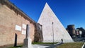 Ancient Rome street view at Ostiense Square with landmark of  Pyramid Cestia urban wall and city skyline with tower of famous gate Royalty Free Stock Photo