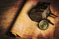 Ancient rotten book and compass on an old parchment