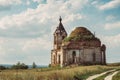 Ancient ruined Russian church or temple overgrown with grass among field Royalty Free Stock Photo