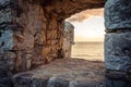 Old ruins background with scenic sunset over sea through ancient castle window with dramatic sky and perspective view with effect Royalty Free Stock Photo