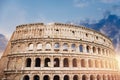 Ancient ruins Colosseum Rome, Italy, background blue sky with clouds, sunset light