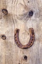 Ancient rusty horseshoe on old wooden plank background