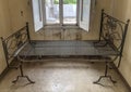 Ancient rusty iron bed in an abandoned and ruined room