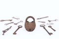 Ancient rusty padlock with collection of keys isolated on white background Royalty Free Stock Photo