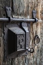 Ancient rusty steel lock bolt with a key hole installed on an old wooden door from medieval age Royalty Free Stock Photo