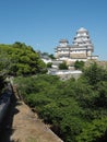 Ancient samurai castle in Himeji city in Japan with white walls, dark tile roofs and stone walls on a sunny day in summer with blu Royalty Free Stock Photo