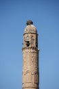 Ancient sandstone minaret with loudspeakers