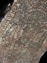 An ancient Scandinavian rune stone. Red rune text and drwaing.