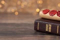 Ancient scroll with seven seals on top of closed holy bible book with bokeh light background