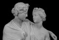 Ancient sculpture of Bacchus and Ariadne. Marble man and woman statue isolated on black background.