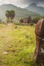 Ancient sculpture sandstone pillars at Vat Phou, South Laos. Couple tourists, mountain and beautiful sun setting backgrounds.