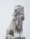 Ancient Sculpture of White sitting Coade stone Lion isolated on white backgrounds, clad strong statue, leadership symbol monument Royalty Free Stock Photo