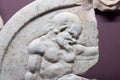 Ancient sculptured image of male on marble disk broken from Mediterranean area.