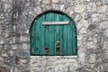 Ancient semicircular window with nailed green wooden shutters. Royalty Free Stock Photo