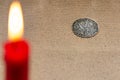 Ancient silver coin and burning candle Royalty Free Stock Photo