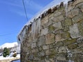 Ancient snowy Palloza round stone house with thatched frozen roof and icicles. Piornedo, Ancares, Lugo, Galicia, Spain. Royalty Free Stock Photo