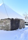 Ancient snowy Palloza round stone house with thatched frozen roof and icicles. Piornedo, Ancares, Lugo, Galicia, Spain. Royalty Free Stock Photo