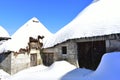 Ancient snowy Palloza stone house with thatched frozen roof and icicles. Piornedo, Ancares, Lugo, Galicia, Spain. Royalty Free Stock Photo