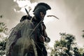 Ancient Spartan warrior in battle dress stands on meadow with shield and sword