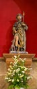 Ancient statue of Saint James with stick and dogs and flowers. Patron of pilgrims. Symbol of Camino de Santiago. Royalty Free Stock Photo