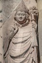 Ancient statue of a smiling and praying monk with peace gesture by hands at magnificent old city Cathedral in Magdeburg, Germany.