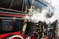 Ancient steam locomotive in steam. Live steam around mechanical Royalty Free Stock Photo