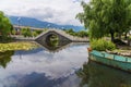 Ancient stone arch bridge and lotus pond in Dali Park, Yunnan Province, China Royalty Free Stock Photo