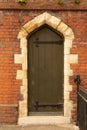 Ancient stone archway with brown wooden door.  Suffolk, UK - July 22nd 2020 Royalty Free Stock Photo