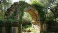 Ancient Stone Archway Overgrown with Greenery in Lush Forest Setting Royalty Free Stock Photo