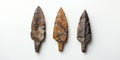 Ancient stone arrowheads with rough texture arranged on light neutral background Royalty Free Stock Photo
