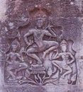 Ancient stone bas-relief on the wall of an abandoned Khmer temple. Stone sculpture of three dancing women