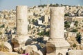 Ancient stone blocks of the ruined columns at the Citadel of Amman with the city at the background in Amman, Jordan.