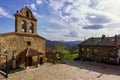 Ancient stone church in medieval village with old houses and blue sky with clouds. La Hiruela Madrid