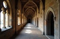 Ancient stone corridor with gothic arches and wooden ceiling. Sunlight creates shadows on floor. Empty historical hallway inside Royalty Free Stock Photo