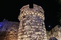 Ancient stone fortification tower illuminated at night with moonlit sky Royalty Free Stock Photo