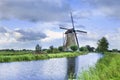 Ancient stone low sail mill near a canal with dramatic clouds, The Netherlands