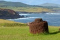 Ancient stone pukao overlooking the rugged coastline of Easter Island Royalty Free Stock Photo